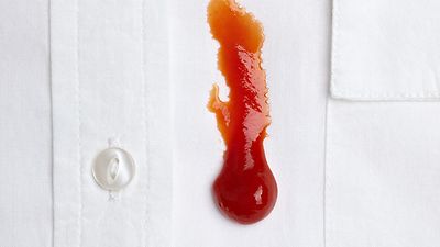 Detailaufnahme: Ketchup-Fleck auf einem weißen Hemd