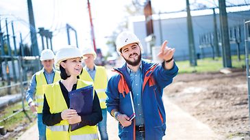 Vier Personen Mainova Team im Außeneinsatz. Er zeigt auf ein Gegenstand außerhalb des Bildes.