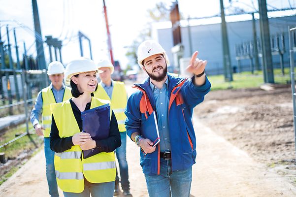 Vier Personen Mainova Team im Außeneinsatz. Er zeigt auf ein Gegenstand außerhalb des Bildes.
