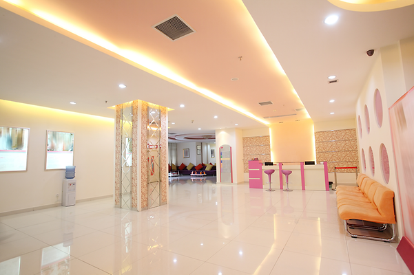 Heller, moderner Warteraum mit orangen Sofas, rosa Stühlen und glänzendem Boden.