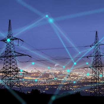 © stock.adobe.com/urbans78 Vernetzte Strommasten vor einer Großstadt