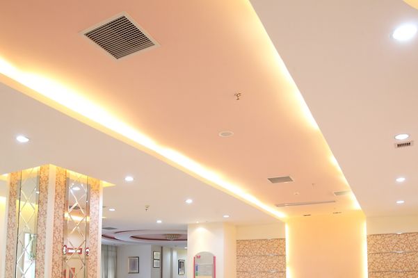 Ein Raum mit leuchtenden LED-Strahlern und LED-Leisten an der Decke.