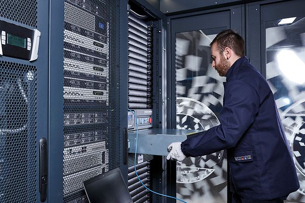 Ein Techniker arbeitet in einem Serverraum und installiert oder wartet Servergeräte.