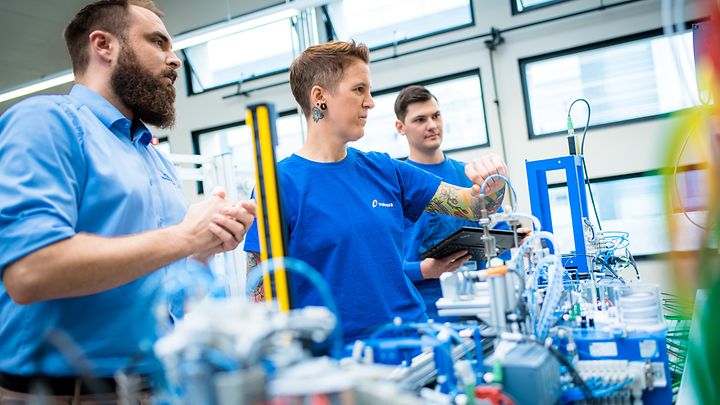 Ausbilder prüft die Messarbeit einer Auszubildenden