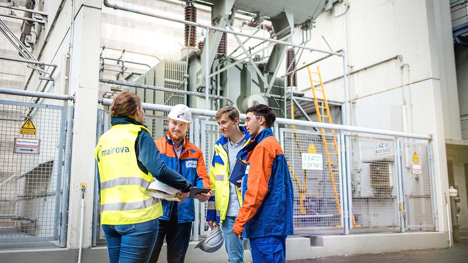 Gruppe Auszubildende vor einen Groß Trafo