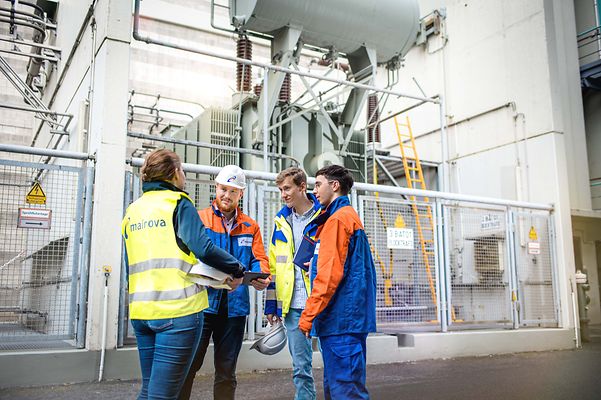 Gruppe Auszubildende vor einen Groß Trafo